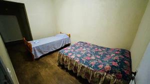 una piccola camera con un letto e una coperta di Apartamento Centro de Mongaguá a Mongaguá Altre 8 foto