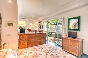 a bedroom with a bed and a television in it at POSEA Collection - Villa Ponente in Positano