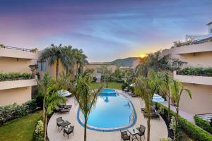 an aerial view of a hotel with a pool and palm trees at Sterling Bagh Ranthambore in Sawāi Mādhopur