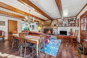 a dining room with a table and a fireplace at Cottage Inn The Woods -- Pond, Pet Friendly, Grill, Wifi, Fire Pit, Deck, Screen Porch, Fireplace, Private in Berkeley Springs