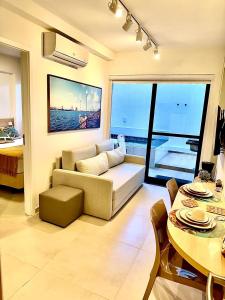 a living room with a couch and a table at Melhor localização Porto Galinhas 50M DO MAR E CENTRINHO - COM E SEM PISCINA PRIVATIVA Family Flats Porto de Galinhas in Porto De Galinhas