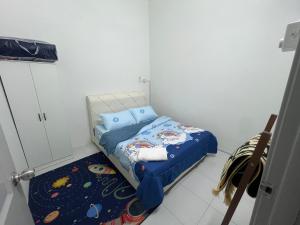 a small bedroom with a bed and a rug at yasmins homestay in Sitiawan