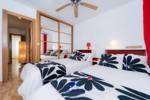 Un dormitorio con dos camas y un ventilador de techo. en Bay Two Beach Apartment, en La Herradura