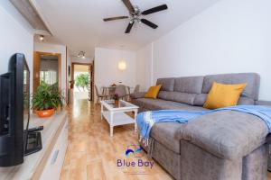 Una sala de estar con un sofá y un televisor. en Bay Two Beach Apartment, en La Herradura