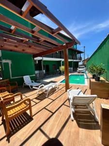 a deck with lounge chairs and a swimming pool at Oásis Pousada in Bertioga