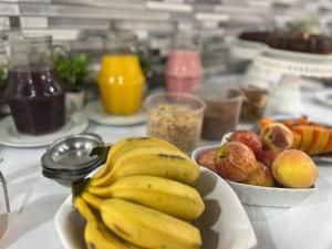 a bowl of bananas and other fruits on a table at Pousada Recanto da Palmeira in Guaíba