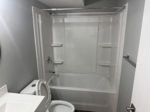 a white bathroom with a toilet and a shower at 2-Bedrooms - On site Parking - near YQR Airport in Regina