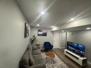 a living room with a couch and a flat screen tv at 2-Bedrooms - On site Parking - near YQR Airport in Regina