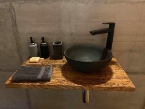 a black bathroom sink on a wooden counter with a sink at La Borbiatte in Montavon