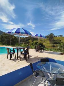 a patio with tables and chairs and umbrellas at Casinha Virtuosa in Monte Sião