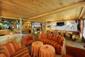 ein Wohnzimmer mit Sofas, Tischen und einer Bar in der Unterkunft Hotel Bellerive Gstaad in Gstaad