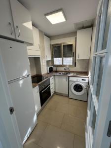 a kitchen with a white refrigerator and a dishwasher at Precioso y luminoso apartamento junto al mar y playa en Garrucha 1A in Garrucha