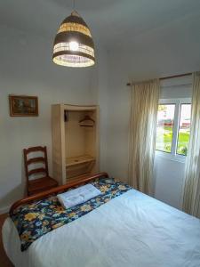 a bedroom with a bed and a chandelier at Montijo Garden - Studio with garden view in Montijo