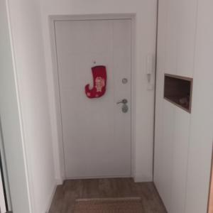 a room with a white door with a red mask on it at Apartman Prodan in Sombor