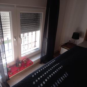 a bedroom with a bed and a window with blinds at Apartman Prodan in Sombor
