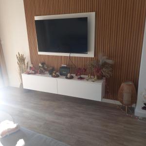 a living room with a television on a wall at Apartman Prodan in Sombor