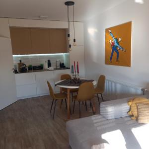 a living room with a table and a kitchen at Apartman Prodan in Sombor