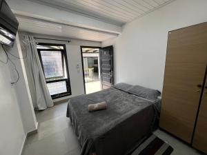 a bedroom with a bed and a large window at Pousada Recanto da Palmeira in Guaíba +41 photos