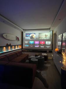 a living room with a couch and a large screen television at Private Loft with Rooftop & Jacuzzi in City Center in Düsseldorf