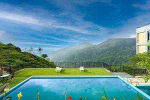 a house with a swimming pool with mountains in the background at Kelvin Eco Resort in Dedugala