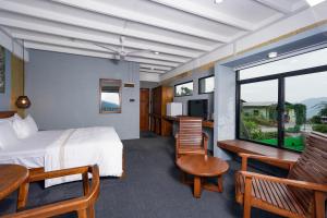a hotel room with a bed and a table and chairs at Kelvin Eco Resort in Dedugala