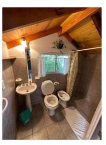 a small bathroom with a toilet and a sink at HOSTEL CASA C Alojamiento, Coworking y Centro Cultural in Villa General Belgrano +22 photos