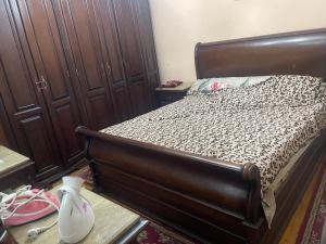 un letto con struttura in legno in una stanza di loran flat a Il Cairo