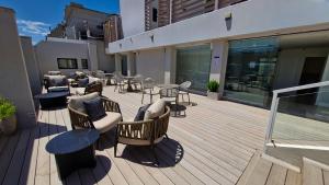 a deck with chairs and tables on a building at Amérian Executive Córdoba Hotel in Córdoba