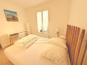 a white bed in a room with a window at Maison de Charme 3 étoiles à 300m de la plage in Saint-Pierre-dʼOléron