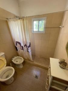 ein Badezimmer mit Toilette und Waschbecken und einem Fenster in der Unterkunft Casa con pileta - Rio Ceballos - a 5 min del centro - Hermosa vista a las sierras in Río Ceballos
