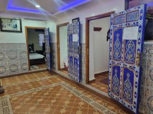 シェフシャウエンにあるHotel Al kassabaの青と白のドアと鏡が備わるお部屋 +37枚の写真