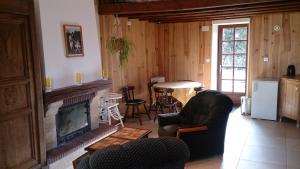 sala de estar con chimenea y mesa en Relais De La Vallée De L'ource en Villars-Montroyer