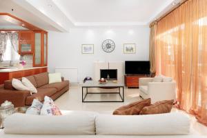 Una sala de estar con un sofá y un televisor. en Meli-Anas House, en Nea Iraklitsa