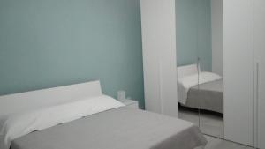 ein weißes Schlafzimmer mit Bett und Spiegel in der Unterkunft BED in Sicily - Camera e Bagno privato in Randazzo