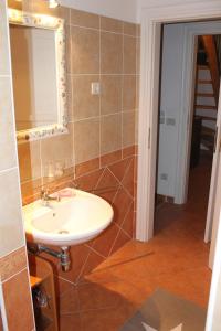 een badkamer met een wastafel en een spiegel bij Villa Convalaria in Sutivan