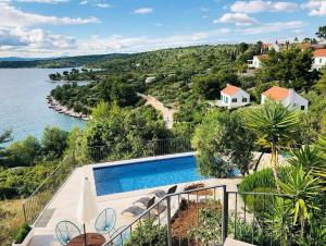 een huis met een zwembad naast een waterlichaam bij Villa Convalaria in Sutivan