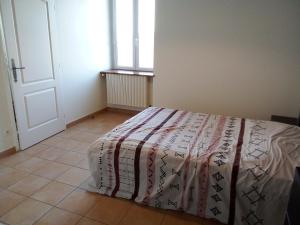 a bedroom with a bed with a blanket on it at Chez Steph in Saint-Germain-Nuelles
