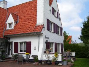 a white house with an orange roof at B&B Villa Fernadine in De Haan