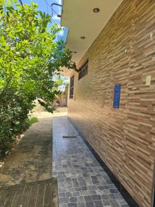 a brick wall of a building with a sidewalk at Hospedaje Mas in Tarapoto +43 photos