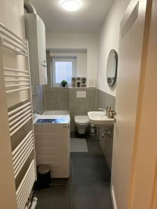 a small bathroom with a sink and a toilet at Schöne 2 Zimmer Wohnung Kingsize-Bett in Augsburg