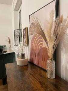 a vase with feathers in it on a wooden table at Schöne 2 Zimmer Wohnung Kingsize-Bett in Augsburg