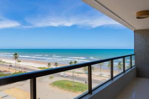a balcony with a view of the beach and the ocean at Desperte com o Azul do Mar - Apê Perfeito para Família! in Cururupe