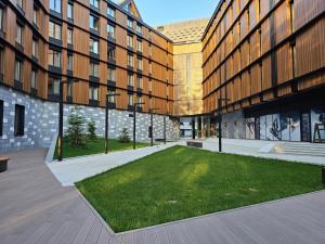 a courtyard in front of a building with a grass field at Woodside Mount Kopaonik in Kopaonik