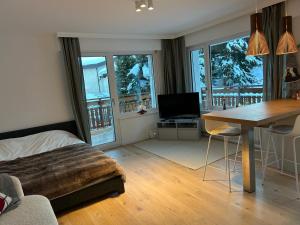 a bedroom with a bed and a desk with a table at New studio in Crans center in Crans-Montana
