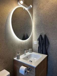 a bathroom with a sink and a mirror at New studio in Crans center in Crans-Montana