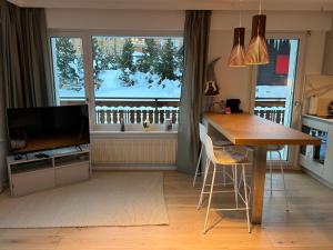 a living room with a television and a table and a kitchen at New studio in Crans center in Crans-Montana +6 photos