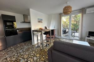 een woonkamer met een bank en een keuken bij La Mimosette Joli appartement 1 chambre tout confort proche de la plage in Le Grau-du-Roi