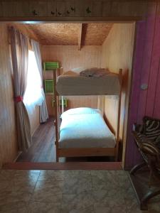 a small room with two bunk beds and a window at Rústica Futaleufú in Futaleufú