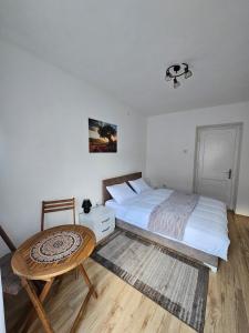 a bedroom with a large bed and a table at Apartman Begovic in Kolašin