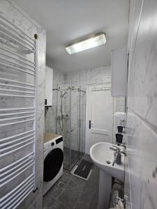 a white bathroom with a sink and a shower at Apartman Begovic in Kolašin